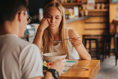 depressed person eating at restaurant