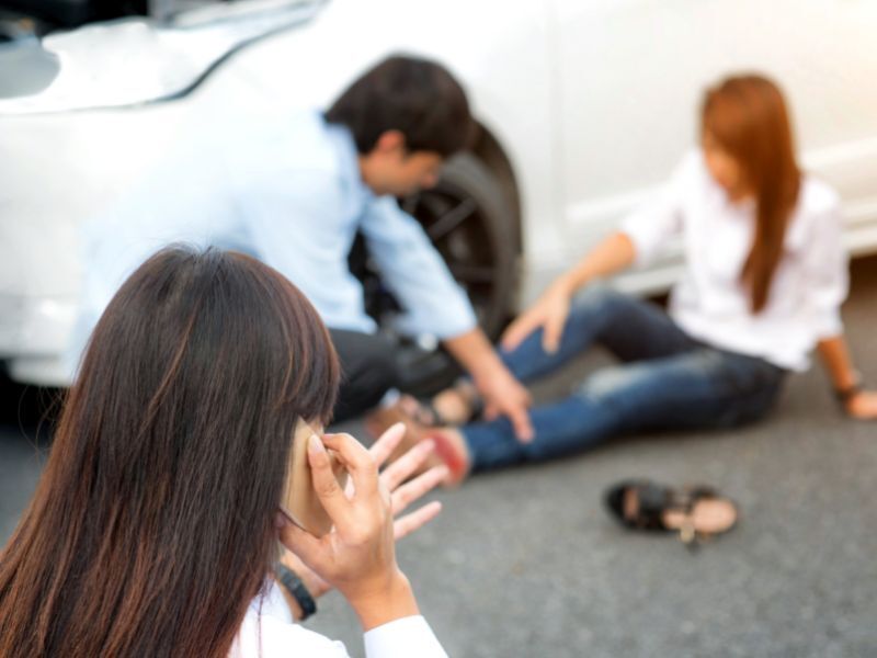 injured passenger laying on the road after a car accident